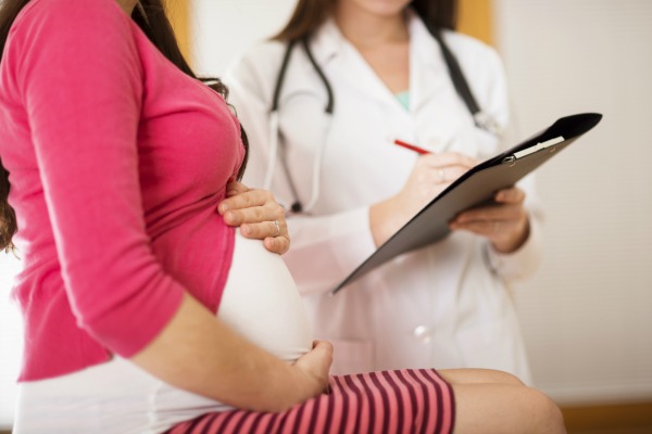 pregnant woman meets with her OBGYN doctor